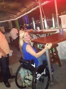 Imagem 2. Mulher em cadeira de rodas tenta utilizar uma mesa normal num restaurante.